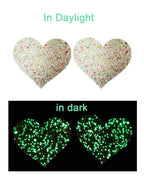 Heart-shaped pasties with glittery finish on a white background, showing 'In Daylight' and 'In Dark' text.